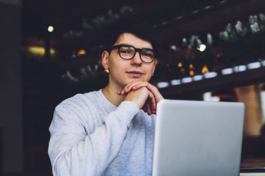 Modern bilgisayarda çalışan ve üretkenlik çalışması için ücretsiz 4G internet bağlantısı kullanan gözlüklerde başarılı bir programcı. Optik gözlüklerde deneyimli bir metin yazarı dizüstü bilgisayarın başında oturuyor.