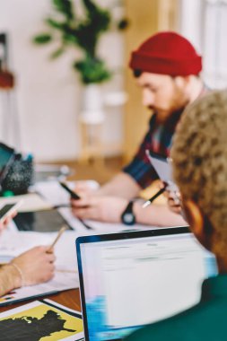 Tasarım projesinde gündelik kıyafet giymiş çok kültürlü gençlerden oluşan bir grup ofiste brifing toplantısı yapıyor. İş stratejisi geliştirmek için birlikte çalışan yaratıcı hipster öğrencileri.