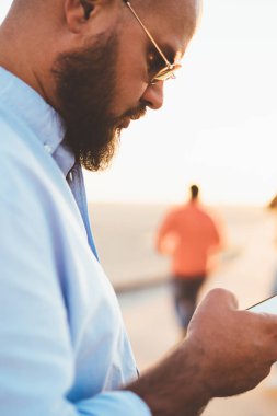 Seçici odak, hipster adam akıllı sosyal ağlar üzerinde telefon açık havada uygulama kullanarak sohbet sokak, genç yakışıklı adam üzerinde iyi bir internet bağlantısı üzerinden mesaj gönderme posta kontrol