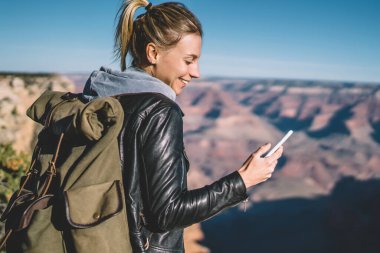 İyi mobil bağlantı, gülümseyen kadın Gezgin dağlarda macera gezisi sırasında uygulama denetimi kullanan tur Büyük Kanyon hiking sırasında telefonda kısa mesaj gönderme olumlu hippi kız