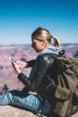 Genç kadın turist mobil veri ağı telefonla mesaj gönderme dağlarda memnun cliff, hippi kız Yolculuk tutkusu için Smartphone uygulama kullanarak üzerinde dinlenme gidin yürüyüş sırasında