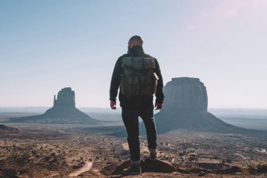 Erkek Gezgin ünlü doğal dönüm noktası ABD keşfetmek kumtaşı oluşumu çölde, sahne manzarayı Simgesel Yapı içinde turistik yere getting sırt çantası adamla hipster bakarak arkadan görünüm