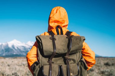 Geniş alanda karla kaplı dağlar ufukta, seyir tatil aktif olarak ABD'de yolculuk sırasında doğa ve çevre keşfetmek harcama hippi kız ayakta sırt çantası ile genç kadın Gezgin