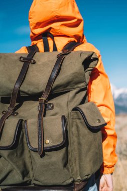 Hiking, yolculuk sırasında doğa Peyzaj ve çevre keşfetmek genç hipster backpacker karla kaplı tepeler, güzel sahne bakmak sırt çantası ile arkadan görünüşü kadın turist turuncu ceketli