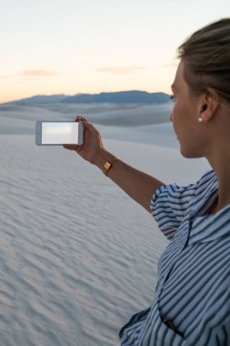 Kadın Yolculuk tutkusu kırpılmış görünümünü tutun güzel kumulları manzara, kadın Gezgin Milli Parkı yaz tatil sırasında sahne doğa fotoğrafçılığı telefon kamera ile fotoğraf çekici smartphone