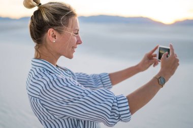 Hippi kız manzara resmini alarak poz selfie smartphone ayakta beyaz kumları Milli Parkı'nda, tarih için genç blogger gülümseyen güzel doğa Yolculuk tutkusu yaz tatillerini zevk gezisi sırasında