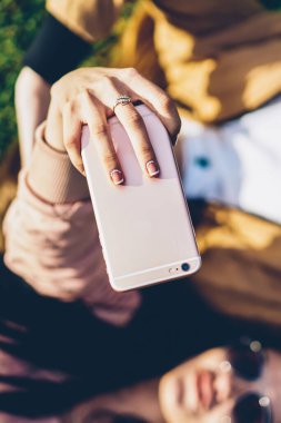 Modern dijital telefon aygıtı tutan ve selfie fotoğrafları açık havada yeşil yalan arkadaşı ile birlikte sosyal ağlar için yapma kadın eli en iyi seçim odak zevk güneşli havalarda çimen