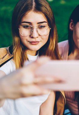 Modern smartphone ön kamera seyir ve sosyal ağlarda yükleme ve birçok getting selfie fotoğraf verme güzel hippi kız arkadaşlarından seviyor. Genç kadın cep üzerinde fotoğraf çekimi