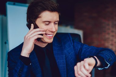 Başarılı bir profesyonel erkek arkadaşıyla cep telefonuyla konuşuyor ve işten sonra giyilebilen akıllı saat takibini kontrol ediyor. Şirket ofisinde dizüstü bilgisayarla oturan mutlu bir iş adamı.