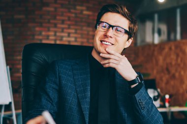 Yeni bir başlangıç projesi hakkında meslektaşlarıyla danışmanlık yaparken girişimcilikten keyif alan mutlu profesyonel işadamı, pozitif gülümseyen erkek ekonomist ofis ortaklarıyla fikirleri tartışıyor