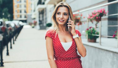 Güzel beyaz kız şık polka noktalar giyip eğleniyor. Şehirde yürüyüş yaparken uluslararası akıllı telefon konuşmaları yapıyor. Gezici bağlantıları kullanarak arayan mutlu bir kadın.