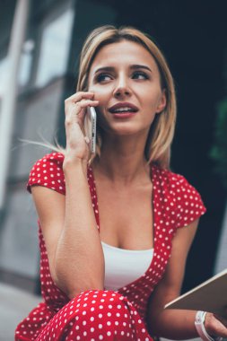 Edebiyat kitabını elinde tutan çekici bir kadın okuyucu ve entrikaları tartışmak için uluslararası çağrı yapıyor. Modern akıllı telefonlardan cep telefonlarına bağlanan güzel bir hippi kız.