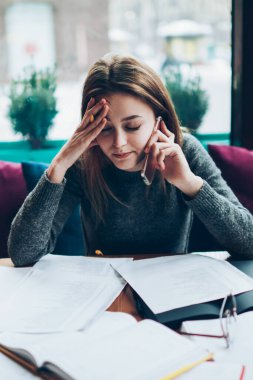 Genç endişeli işkadını yeni modern akıllı telefon aracılığıyla patronla stresli bir konuşma yapıyor. Depresyondaki kadın yönetici baş ağrısı çekiyor. Cep telefonu konuşmaları sırasında kötü haberler alıyor.