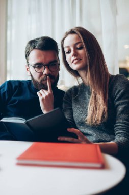 20 'li yaşlarda iki genç, birlikte çalışma alanında edebiyat okumak için zaman harcıyor. Erkek ve kadın blogcular sosyal ağ için yeni bir gönderi planlıyorlar.