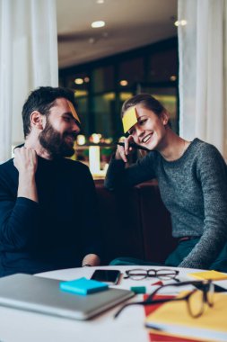 Alnında yapışkan notlarla gülümseyen ve neşeli isim oyunları oynayan neşeli kafeteryada toplanmış neşeli, başarılı erkek ve kadın dinleniyor ve içeride eğleniyor.