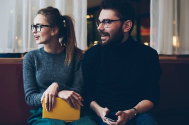 İki blogcu göz düzeltmesi için gözlük takıyor. Kafeteryada boş vakitlerini rahat bir şekilde geçiriyorlar. Yanında akıllı telefonlu bir adam otururken hippi kız kitap tutuyor.