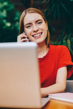 İnternette çalışan gülümseyen kadın yazılım geliştiricisinin portresi Wi-Fi 'ye ve arayan arkadaşına bağlıyken mutlu hippi kız pozitif konuşma sırasında modern netbook' a yeni uygulama yüklüyor.