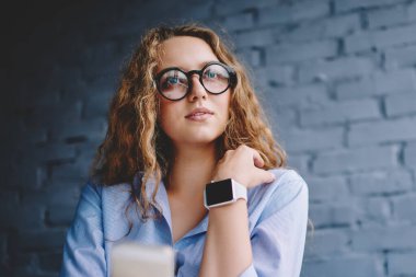 Kafeterya kablosuz ağına bağlı cep telefonuna uygulamayı yerleştirirken düşünceli hippi kızın düşünceli bakışları sosyal ağda yayınlamayı düşünen düşünceli kadın.