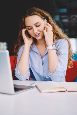 Başarılı kadın serbest çalışan, dizüstü bilgisayarın güncellenmesi konusunda müşteri hizmetlerine danışmanlık yapan, notlar için ders kitabı kullanan, modern akıllı telefon aygıtı ile arkadaşlarıyla iletişim kuran pozitif kadın.