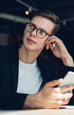 Resmi kıyafetli, gözlüklü, elinde cep telefonu ve sıcak içecekle oturan rüya gibi restoran yöneticisinin elinden.