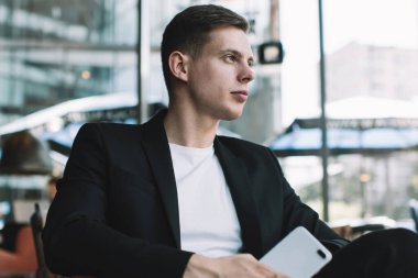 Resmi ceketli ve rahat koltukta oturan ve uzaktan çalışma sırasında mola veren kendine güvenen erkek girişimcilerden.