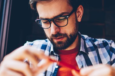 Çalışmak için Vizyon Düzeltme alanı coworking optik gözlük dalgın sakallı genç adam. Kahve dükkanı iç oturma rahat şık gömlek giymiş konsantre hipster adam