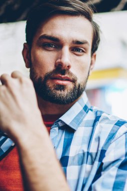 Yarım uzunluk portre yakışıklı genç adam gözlük kahvehane iç dinlenme elinde tutarken kameraya bakan sakallı. Şık gömlek kafede oturan adam iyi görünümlü hipster