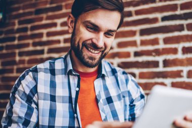 Online eğitsel dijital dokunmatik yüzey 4 g internet bağlantısı üzerinden izlerken neşeli sakallı erkek blogger. Sohbet rahat gömlek içinde online modern tablet cihaz üzerinde olumlu hipster adam giyinmiş