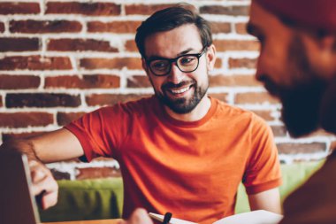 Dizüstü bilgisayarda işaret ve öğrenci için görev açıklayan profesyonel erkek grafik tasarımcı. İki hister yaratıcı genç adam, modern bilgisayar ortak proje üzerinde birlikte bağlı 4 g için Internet