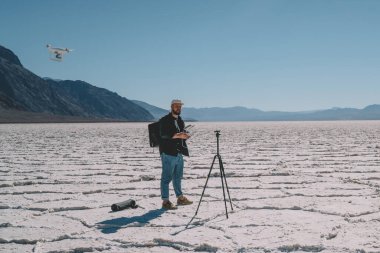 Tüm erkek turist vücudu tripodun yanında duruyor ve ölüm vadisinde tatillerini geçirirken uzaktan çekim yapmak için insansız hava aracı yolluyor.
