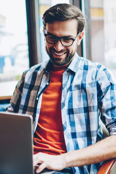 Gülüyor ve laptop sosyal ağlarda arkadaşlarınızla çevrimiçi sohbet neşeli sakallı hippi adamın bağlantısı için 4 g kablosuz internet. Komik Haberler Netbook coworking içinde okuma olumlu erkek blogger