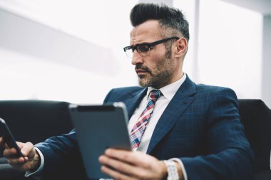 Modern Dokunmatik ped cihaz üzerinde hesap bankacılık profili güncelleştirilirken Smartphone cep telefonu ile gelen sms mesajý okuma formal giyim emin girişimci. Bluetooth ile medya paylaşımı gurur CEO'su Olgun