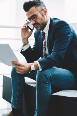 Zengin işadamı metin belgelerinin smartphone aygıt üzerindeki banka hesabınızı kontrol etmek için arıyor operatör için ise orta yaşlı okuma finansal raporlarında. Başarılı gurur CEO'su cep üzerinde konuşuyor