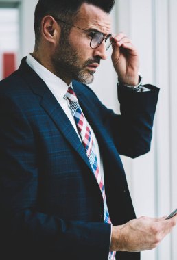 Düşünceli emin gurur CEO'su görünümünü 50 yıl eski pencereden dışarı bakıyor finansal haber tablet ile Web sitesi güncelleştirilirken bağlı 4 g için yan Internet. Dokunmatik yüzey ile başarılı bir tüccar durulması