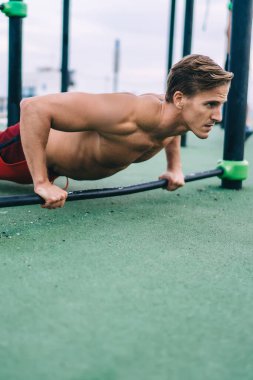 Deneyimli beyaz adam sabah antrenmanından zevk alıyor. Kolları çalıştırmak için şınav çekiyor. Kas sporcusu spor sahasında fiziksel formunu korumak için dayanıklılık egzersizi yapıyor.