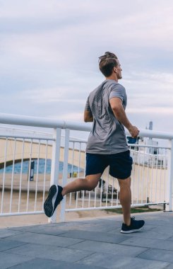 Kafkas erkek koşucunun aktif olarak sabahları koşuya çıkması sportif vücut şeklini korumak için boş vaktini harcaması, erkek sporcunun şehir ortamlarında antrenman yapması ve enerjinin tadını çıkarması.