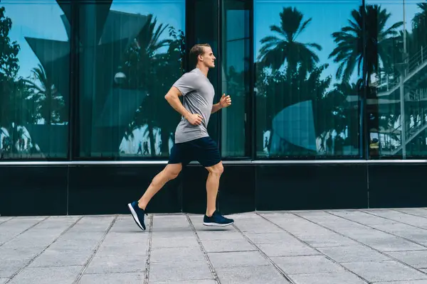 Genç, zayıf, kaslı erkek koşucu şehir merkezlerinde koşuyor. Eğitim gücü ve esnekliği, ciddi beyaz sporcu kardiyo çalışması yapıyor. Aktif yaşam tarzını ve şeklini koruyor.