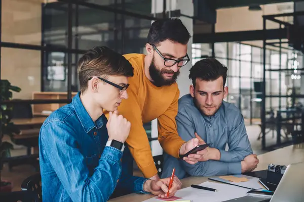 Beyaz tenli genç, iletişim, iletişim ve ortaklık kavramında iş birliği yaparken cep telefonundan mesajlar yolluyor ve mesajlar yolluyor.