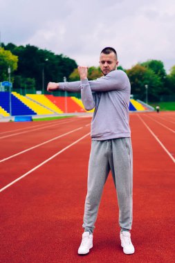 Aktif giyimli güçlü beyaz erkek vücudunun üst kısımları için ısınma egzersizleri yapıyor. Egzersiz için hazırlanıyor. Yakışıklı hippi sağlıklı yaşam tarzını koruyor.