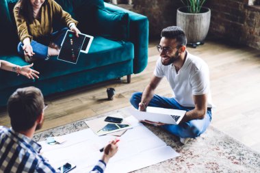 Lotus 'ta oturan mutlu, etnik çeşitliliğe sahip meslektaşlarımızdan gülümseyerek ve birbirlerine bakarak başlangıç konularını tartışıyoruz.