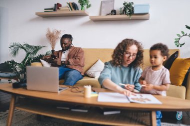 Sosyal medyada sohbet etmek ve mesajlaşmak için cep telefonu kullanan Afro-Amerikalı bir adam birlik ve aile bağlarını görmezden geliyor. Koyu tenli erkek blogcu cep telefonu mesajı gönderiyor.