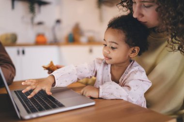 Çalışan bir anne iş hayatını dengeliyor ve ev içinde ebeveynlik yapıyor. Karışık ırk çocuğu, modern dizüstü bilgisayarla 4G 'ye bağlı iş görüşmesinde annesiyle vakit geçiriyor