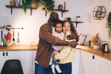 Mutlu aile bağları birbirine bağlı bir bağ ve evde samimi bir anın paylaşılması yoluyla gösterildi. Günlük hayatta birlik ve kabulü vurgulayan mutlu çok ırklı aile portresi