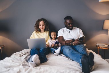 Aile bağları kurmak için çağdaş mobil ve laptop teknolojisi kullanan karı-koca çeşitliliği - ağda sosyal bağımlılık kavramı, çocuk sitelerinde gezinen çok ırklı ebeveynler