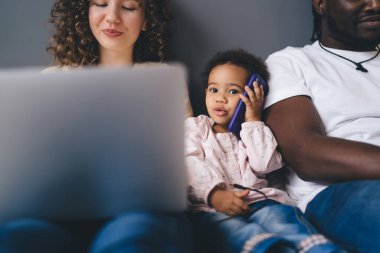 Güzel bir çocuğun portresi cep telefonu cihazlarını kullanarak aile içi aile içi ilişkilerinde anneyi ve babayı aramak ve cep telefonu sohbeti yapmak için kullanması.