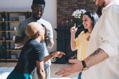 Modern apartman dairesinde toplanıp birbirlerine bakarken bir grup modern kadın ve erkek mutlu bir şekilde sohbet ediyorlar.