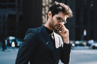 Şık giyinmiş Avrupalı bir adam cep telefonu uygulaması üzerinden uluslararası akıllı telefon görüşmesi yapmak için gezici internet bağlantısını kullanıyor.