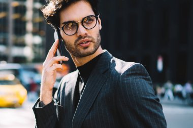 Şık takım elbiseli başarılı bir adam cep telefonu uygulaması üzerinden uluslararası akıllı telefon görüşmesi yapmak için gezici internet bağlantısını kullanıyor, resmi olarak giyinmiş iş adamını arıyor.