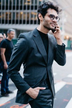 Başarılı, şık giyinmiş genç işadamı akıllı telefondan iş arkadaşına sesleniyor. Metropolis caddesinde Zebra 'yı geçiyor. Gururlu CEO dışarıda cep telefonuyla konuşurken gülümsüyor.