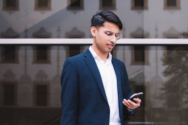 Resmi olarak başarılı bir erkek girişimci şehir ortamında açık havada duran akıllı telefondan mektup okur, genç 20 'li yaşlarda gururlu bir adam 4G üzerinden cep telefonuyla sohbet eder ve mesajlar gönderir.